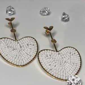 gold-colored earrings with white heart-shaped